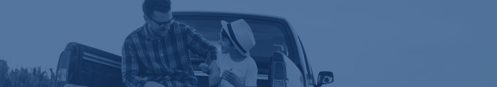 Adult and child sitting on tailgate of truck